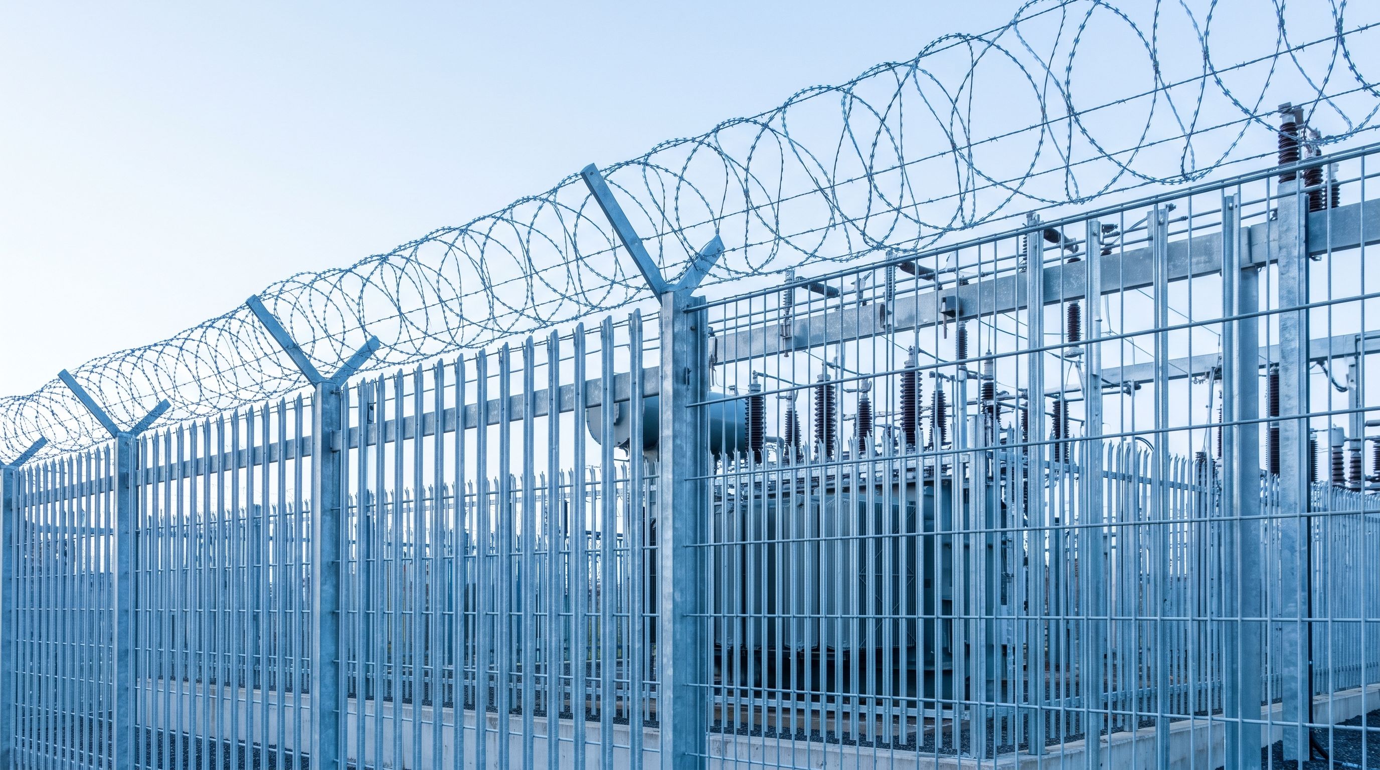 Perimeterzaun einer kritischen Infrastruktur im Morgenlicht